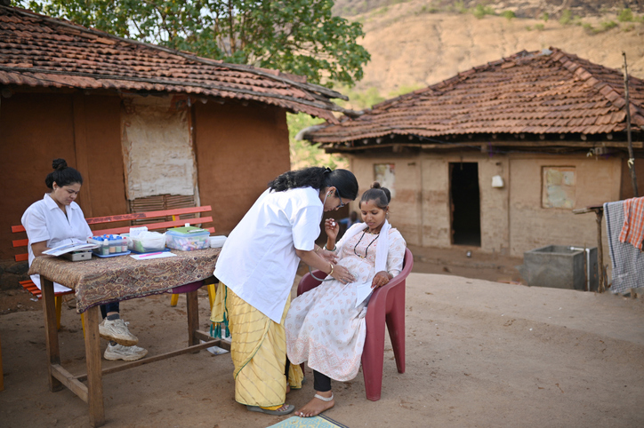 An Indian woman is providing maternal immunization to a child in an enabling environment.